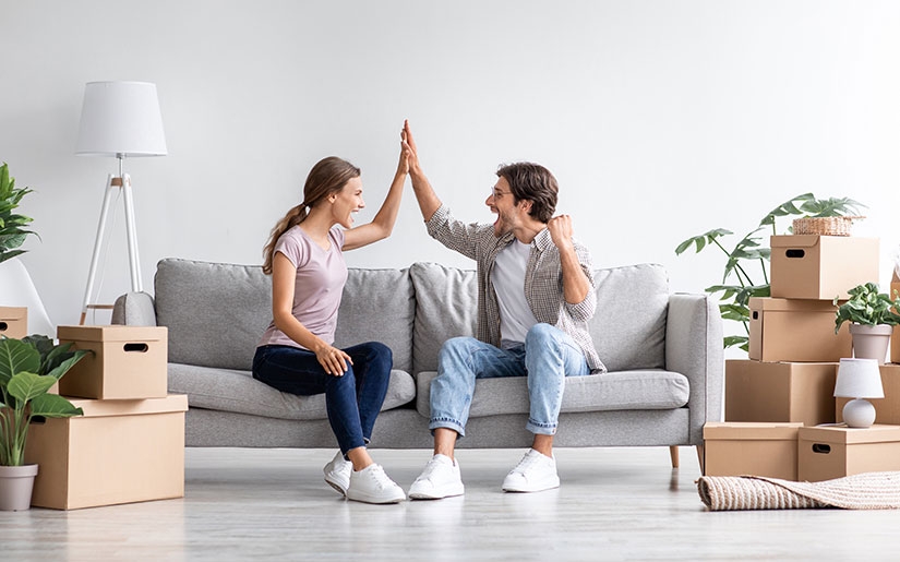 זוג יושב על הספה בדירה החדשה שרכשו בתהליך של התחדשות עירונית